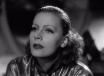 Movie still from “Grand Hotel” (1932), directed by Edmund Goulding – An old black and white photo of a woman in a leather jacket; Close Up shot, High angle