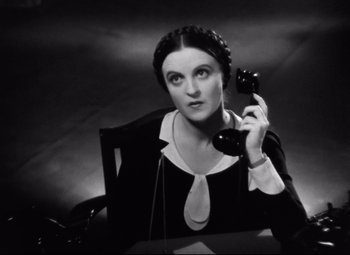 Movie still from “Grand Hotel” (1932), directed by Edmund Goulding – A woman sitting at a table talking on a phone; Close Up shot, High angle