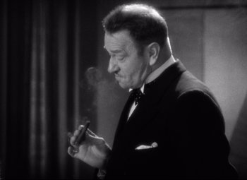 Movie still from “Grand Hotel” (1932), directed by Edmund Goulding – A black and white photo of a man smoking a cigar; Close Up shot, Low angle
