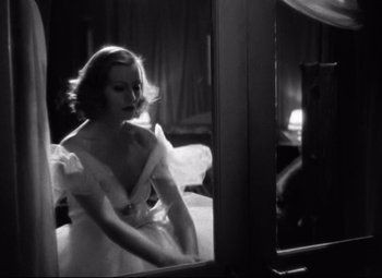 Movie still from “Grand Hotel” (1932), directed by Edmund Goulding – A black and white photo of a woman looking in a mirror; Medium shot, Low angle