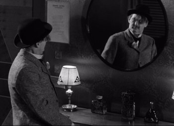 Movie still from “Grand Hotel” (1932), directed by Edmund Goulding – A man is looking at himself in the mirror; Medium shot, Over the shoulder angle