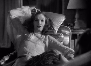 Movie still from “Grand Hotel” (1932), directed by Edmund Goulding – An old photo of a woman laying in a chair; Medium shot, High angle