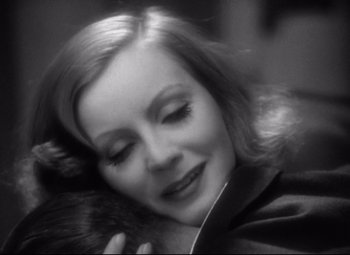 Movie still from “Grand Hotel” (1932), directed by Edmund Goulding – A black - and - white photo of a woman hugging a cat; Close Up shot, High angle