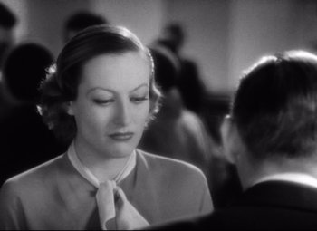Movie still from “Grand Hotel” (1932), directed by Edmund Goulding – A woman wearing a suit and tie talking to a man in a suit and tie; Close Up shot, Over the shoulder angle