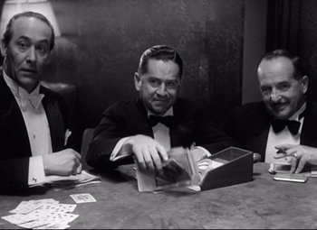 Movie still from “Grand Hotel” (1932), directed by Edmund Goulding – Three men sitting at a table playing cards; Medium shot, High angle