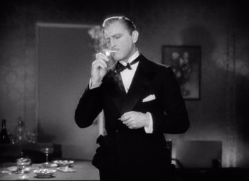 Movie still from “Grand Hotel” (1932), directed by Edmund Goulding – A man in a tuxedo smoking a cigarette; Medium shot, Low angle