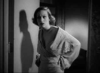 Movie still from “Grand Hotel” (1932), directed by Edmund Goulding – A black - and - white photo of a woman standing in a room; Medium shot, Low angle
