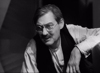 Movie still from “Grand Hotel” (1932), directed by Edmund Goulding – An older man wearing glasses and a vest; Close Up shot, Low angle