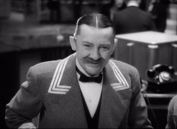 Movie still from “Grand Hotel” (1932), directed by Edmund Goulding – An older man in a jacket and bow tie; Close Up shot, Low angle