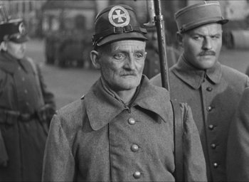 Movie still from “The Grand Illusion” (1937), directed by Jean Renoir – A black and white photo of a man in a military uniform; Medium shot, Low angle