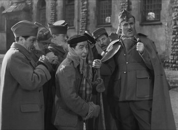 Movie still from “The Grand Illusion” (1937), directed by Jean Renoir – A black and white photo of a group of men in uniform; Medium shot, Over the shoulder angle