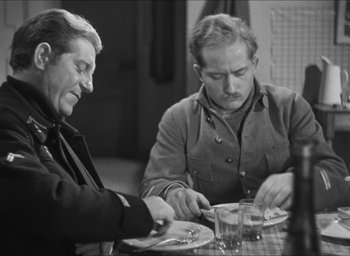 Movie still from “The Grand Illusion” (1937), directed by Jean Renoir – Two men sitting at a table with plates of food in front of them; Medium shot, Over the shoulder angle