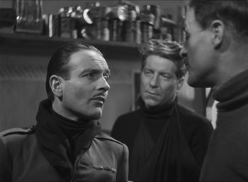 Movie still from “The Grand Illusion” (1937), directed by Jean Renoir – A group of men standing next to each other in a room; Medium shot, Over the shoulder angle