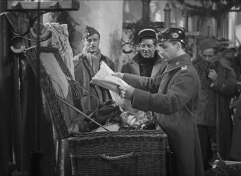 Movie still from “The Grand Illusion” (1937), directed by Jean Renoir – An old photo of a man reading a newspaper; Medium shot, High angle