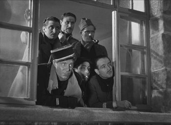 Movie still from “The Grand Illusion” (1937), directed by Jean Renoir – A black and white photo of a group of men in uniform; Medium shot, Low angle