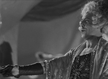 Movie still from “The Grand Illusion” (1937), directed by Jean Renoir – An older woman is holding her hand out to someone; Medium shot, Low angle