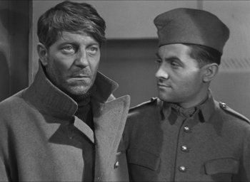 Movie still from “The Grand Illusion” (1937), directed by Jean Renoir – A man in a military uniform standing next to another man in a military uniform; Medium shot, Over the shoulder angle