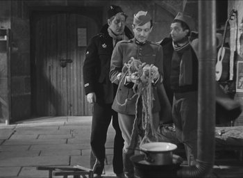 Movie still from “The Grand Illusion” (1937), directed by Jean Renoir – A group of men standing next to each other in a room; Medium shot, High angle