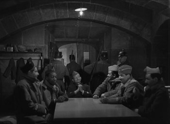 Movie still from “The Grand Illusion” (1937), directed by Jean Renoir – A group of men sitting around a wooden table; Wide shot, High angle