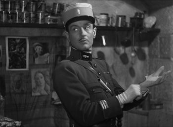 Movie still from “The Grand Illusion” (1937), directed by Jean Renoir – A man in a military uniform holding papers; Medium shot, Low angle