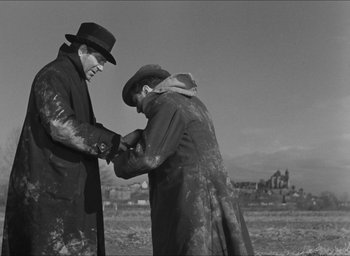 Movie still from “The Grand Illusion” (1937), directed by Jean Renoir – Two men in a field touching one of them's hands; Medium shot, Over the shoulder angle
