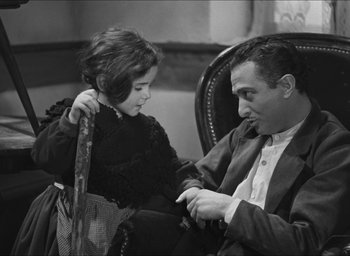 Movie still from “The Grand Illusion” (1937), directed by Jean Renoir – A man sitting next to a little girl; Medium shot, High angle