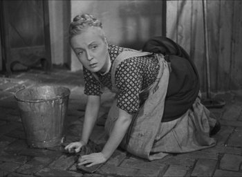 Movie still from “The Grand Illusion” (1937), directed by Jean Renoir – An old photo of a woman cleaning the floor; Medium shot, High angle