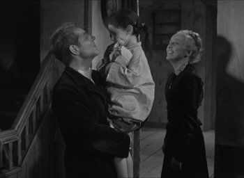 Movie still from “The Grand Illusion” (1937), directed by Jean Renoir – A black and white photo of a man holding a little girl; Medium shot, Over the shoulder angle