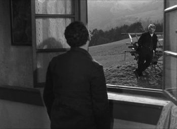 Movie still from “The Grand Illusion” (1937), directed by Jean Renoir – An older woman looking out of a window at an outdoor scene; Wide shot, Over the shoulder angle