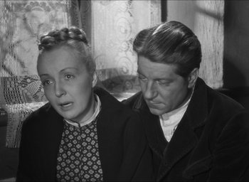 Movie still from “The Grand Illusion” (1937), directed by Jean Renoir – An older woman sitting next to a younger man; Medium shot, High angle