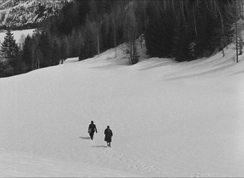 Movie still from “The Grand Illusion” (1937), directed by Jean Renoir – Two people walking up a snowy hill on skis; Extreme Wide shot, High angle