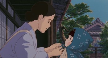 Movie still from “Grave of the Fireflies” (1988), directed by Isao Takahata – An animated scene of a woman holding a doll; Medium shot, Low angle