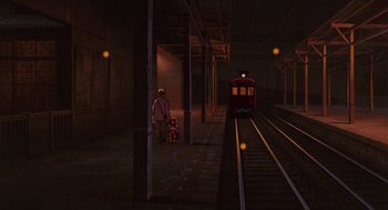 Movie still from “Grave of the Fireflies” (1988), directed by Isao Takahata – Two people standing on a train platform next to a train; Wide shot, Low angle