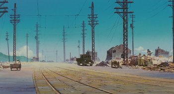 Movie still from “Grave of the Fireflies” (1988), directed by Isao Takahata – An image of an abandoned train yard with a truck parked on the tracks; Extreme Wide shot, Low angle