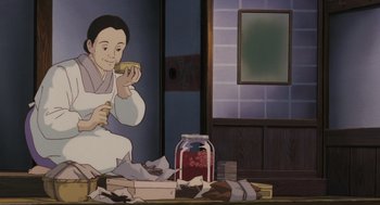 Movie still from “Grave of the Fireflies” (1988), directed by Isao Takahata – An animated picture of a man eating a sandwich; Medium shot, High angle