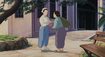 Movie still from “Grave of the Fireflies” (1988), directed by Isao Takahata – Two people standing next to each other on the sidewalk; Wide shot, Low angle