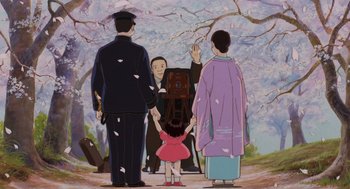Movie still from “Grave of the Fireflies” (1988), directed by Isao Takahata – An animated scene of a man and a woman holding hands with a young girl; Medium shot, Low angle