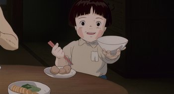 Movie still from “Grave of the Fireflies” (1988), directed by Isao Takahata – A child sitting at a table holding a bowl of food; Medium shot, High angle