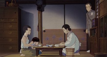 Movie still from “Grave of the Fireflies” (1988), directed by Isao Takahata – An animated scene of three people sitting at a table; Wide shot, Low angle