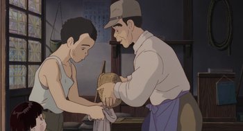 Movie still from “Grave of the Fireflies” (1988), directed by Isao Takahata – An animated picture of a man and a boy; Medium shot, Low angle