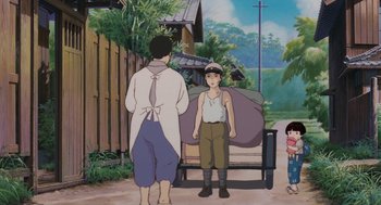 Movie still from “Grave of the Fireflies” (1988), directed by Isao Takahata – A scene of two people standing in front of a cart; Wide shot, Low angle