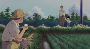 Movie still from “Grave of the Fireflies” (1988), directed by Isao Takahata – An image of a man and a child in a field; Wide shot, Low angle