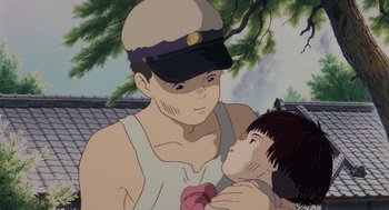 Movie still from “Grave of the Fireflies” (1988), directed by Isao Takahata – An animated picture of a man holding a child; Close Up shot, Low angle