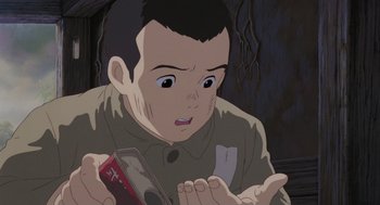Movie still from “Grave of the Fireflies” (1988), directed by Isao Takahata – An animated man is looking at something in his hand; Close Up shot, High angle