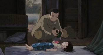 Movie still from “Grave of the Fireflies” (1988), directed by Isao Takahata – An animated scene of a man feeding a child; Medium shot, High angle