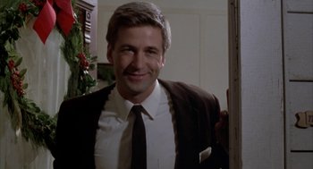 Movie still from “Great Balls of Fire!” (1989), directed by Jim McBride – A man in a suit and tie smiling; Medium shot, Low angle
