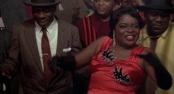 Movie still from “Great Balls of Fire!” (1989), directed by Jim McBride – A man and a woman dancing in front of a group of people; Medium shot, Low angle