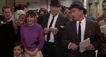 Movie still from “Great Balls of Fire!” (1989), directed by Jim McBride – A group of people standing next to each other in a room; Medium shot, Over the shoulder angle