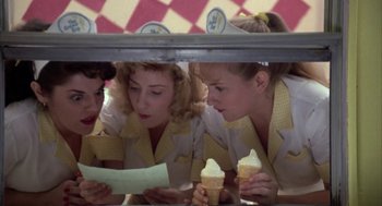 Movie still from “Great Balls of Fire!” (1989), directed by Jim McBride – A group of women sitting next to each other holding cones; Medium shot, Low angle