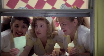 Movie still from “Great Balls of Fire!” (1989), directed by Jim McBride – A group of women sitting next to each other holding ice cream cones; Medium shot, High angle